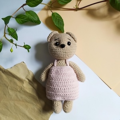 Picture of crochet brown bear with an overall pink
                dress.